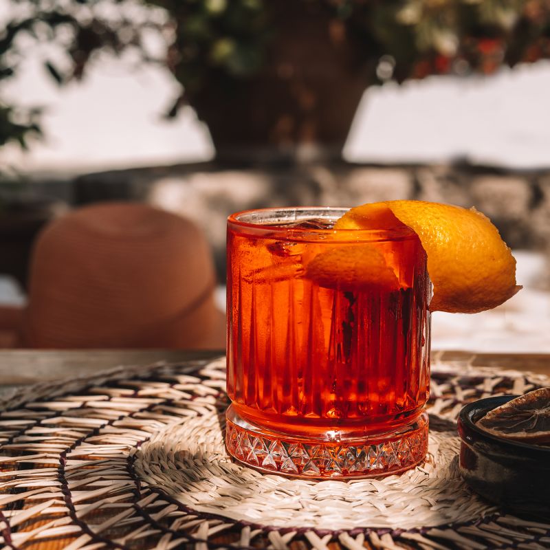 Gin campari old fashioned cocktail on outdoor table