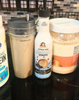 Salted Dark Chocolate Sinless Syrup and protein shake ingredients on obsidian counter