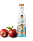 Bottle of Sugar Free Sinless Syrups Apple Crisp Coffee Syrup with two red apples on a white background