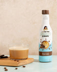 Sugarfree mocha syrup bottle with a bulletproof coffee on a beige background