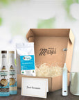 Gift box with Miss Mary's branding, including coffee products and a toothbrush, on a wooden surface.