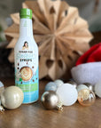 Irish Cream Sinless Syrup on a table decorated with Christmas ornaments and santa hat against blurred background