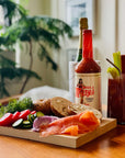 Mis Mary's Bloody mary mix and brunch food on wood table with blurred background