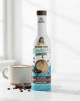 Salted Dark Chocolate Sinless Syrup bottle and chocolate pieces on white background