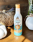 Toasted marshmallow coffee syrup surrounded by decorativep umpkins on wood surface