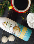 Sugar-free white chocolate Sinless syrup bottle with a holiday cup of coffee and evergreen decor