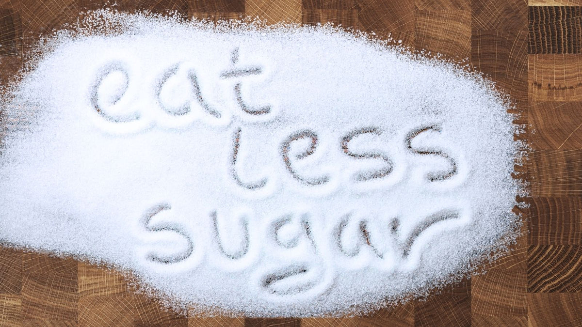 words "eat less sugar" written into spilled sugar on butcher block