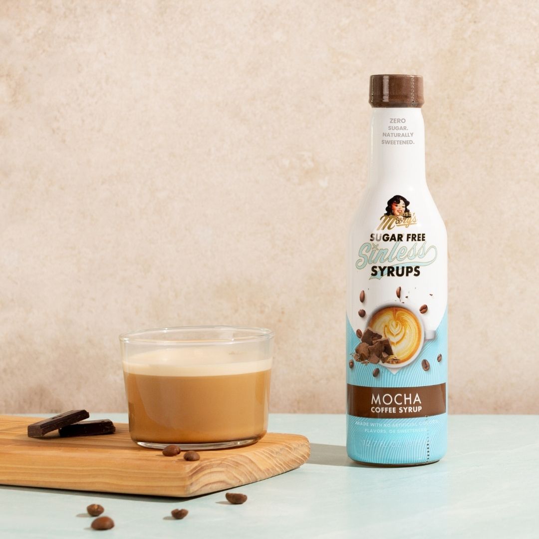 Sugarfree mocha syrup bottle with a bulletproof coffee on a beige background