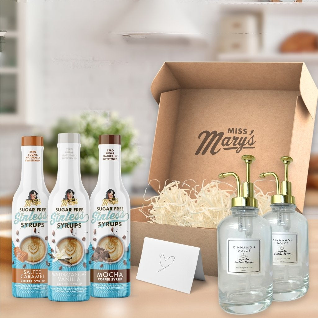 Bottles of sugar-free syrups and glass bottles with pumps in front of a 'Miss Mary's' branded box.