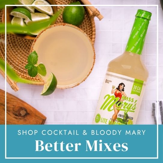 Lite margarita mix bottle and glass with limes on white table