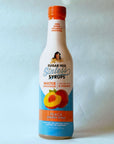 Miss Mary's Peach Sugar Free Sinless Syrup bottle on blue background