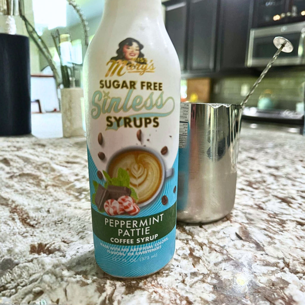 Peppermint Pattie Sinless Syrup with stainless steel pitcher on granite counter.