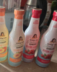 Four bottles of Fruit Sinless Syrups on a countertop with blurred background