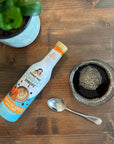 Pumpkin Spice Sugar-free Sinless Syrup on wood table with coffee, spoon, and plant