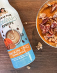 Bottle of Miss Mary's Sugar Free Sinless Syrups Pumpkin Spice Coffee Syrup next to a bowl of pumpkin pie with pecans on a wooden surface.