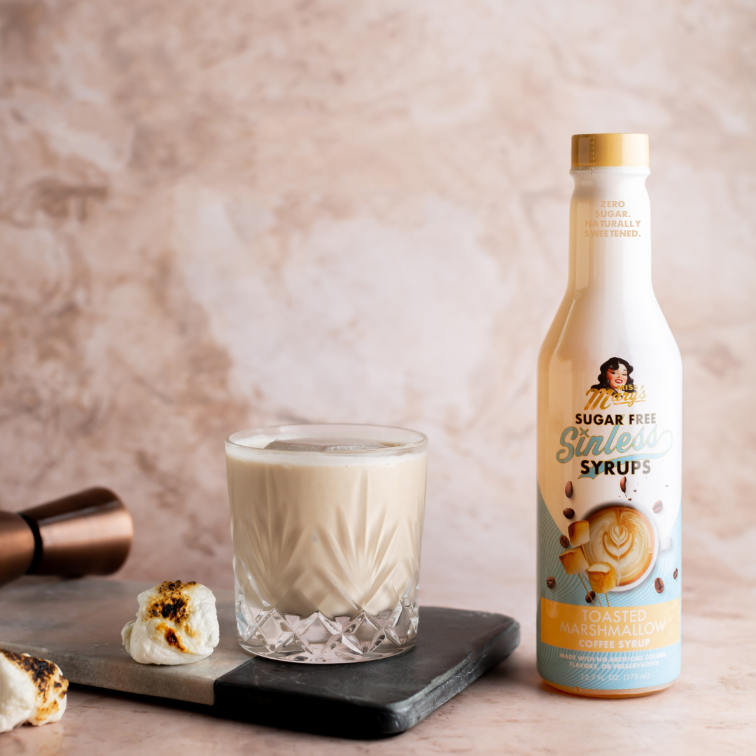 Toasted Marshmallow Sinless Syrup with a White Russian cocktail and marshmallows on a beige background