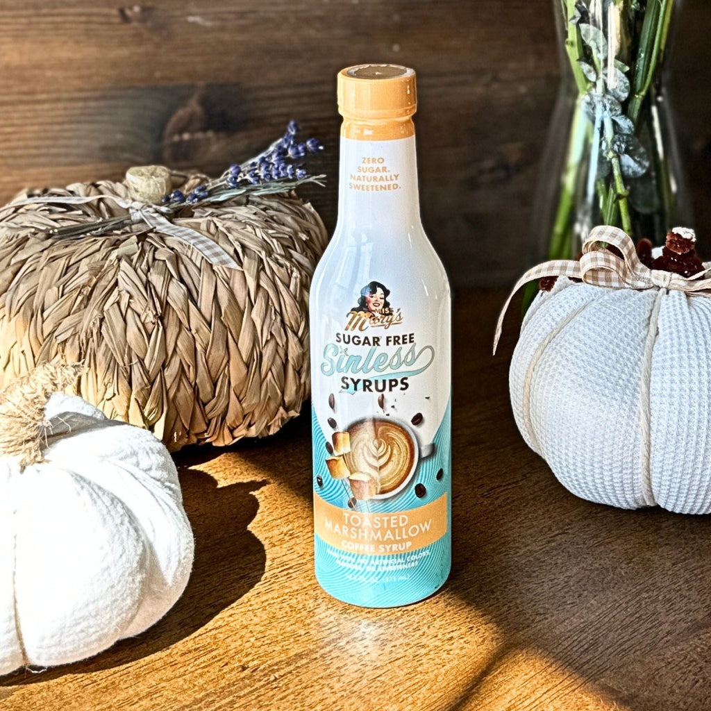 Toasted marshmallow coffee syrup surrounded by decorativep umpkins on wood surface