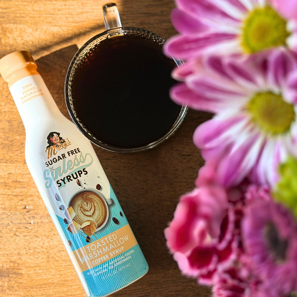 Toasted Marshmallow sugar-free syrup with coffee and pink flowers on wood table