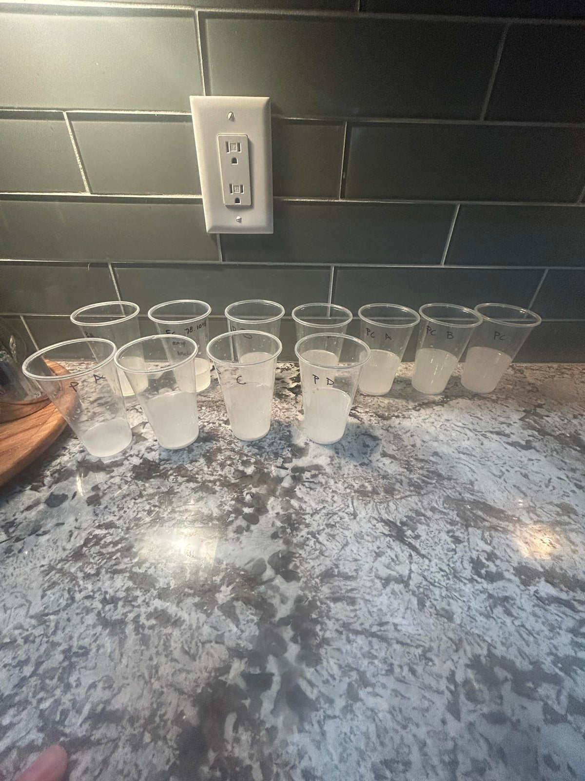 multiple cups with pale liquid on granite counter